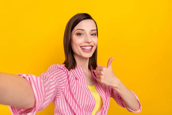 Portrait de charmante dame gaie prendre selfie main montrer pouce vers le haut rayonnant sourire isolé sur fond de couleur jaune — Photo