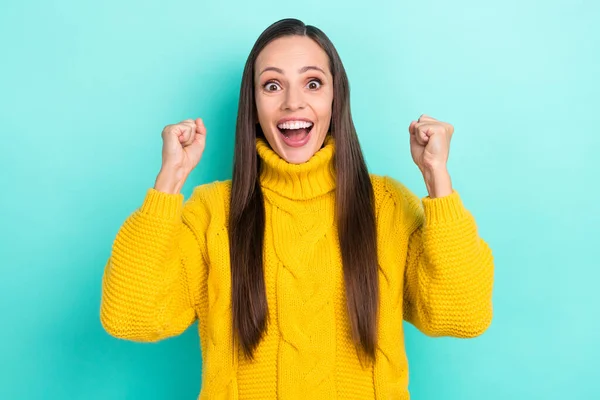 Фото чарівної щасливої жінки в жовтому светрі, що кричить піднімаються кулаки ізольовані бірюзового кольору фону — стокове фото