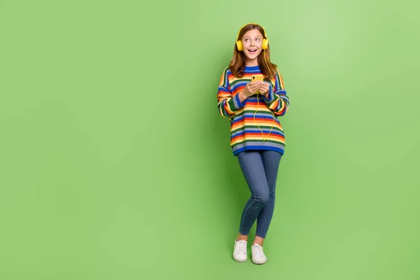 Teljes hossz testméret kilátás vonzó trendi vidám lány hallgat pop másolás tér hirdetés elszigetelt felett élénk zöld színű háttér — Stock Fotó