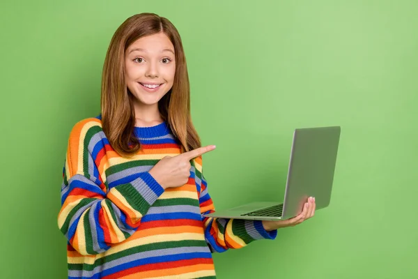 Retrato de chica divertida alegre atractiva usando el ordenador portátil demostrando aprender educación estudio aislado en el fondo de color verde brillante —  Fotos de Stock