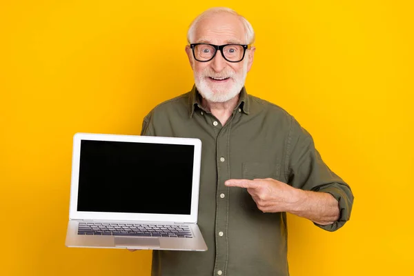 Foto de belo homem idoso alegre indicar dedo vazio exibição de espaço isolado no fundo de cor amarela — Fotografia de Stock