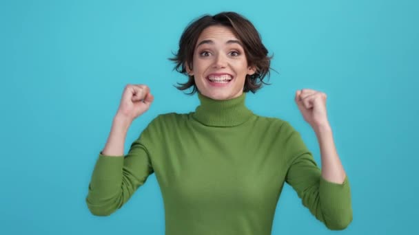 Dame extatique se réjouissent incroyable poing de victoire jusqu'à isolé fond de couleur bleue — Video