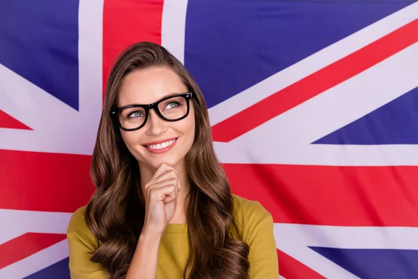 Fotografie pěkné veselá dáma ruku na bradě vypadají zvědavě copyspace izolované na britské vlajce pozadí — Stock fotografie