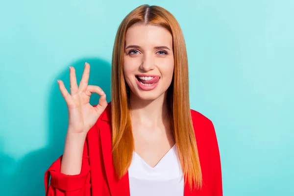 Foto de charmoso flerte laranja mulher cabelo vestido casaco vermelho mostrando língua okey sinal isolado cor ciano fundo — Fotografia de Stock