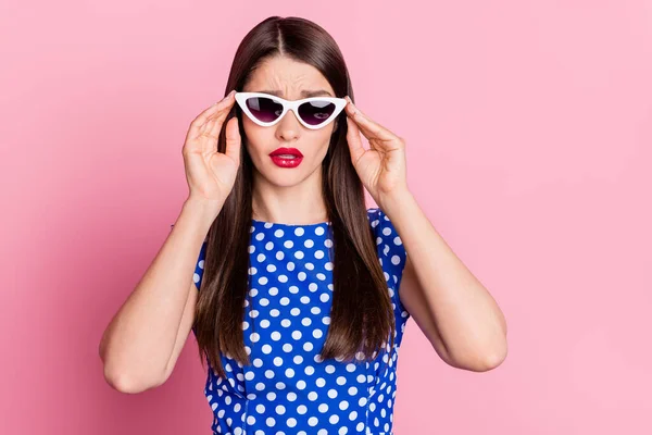 Fotografie mladé atraktivní ženy nešťastné náladové negativní ruce dotykové brýle izolované přes růžové barvy pozadí — Stock fotografie