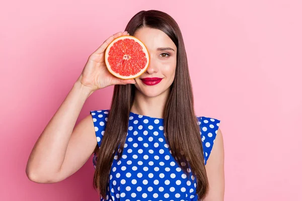 Foto de mujer atractiva joven feliz sonrisa positiva cubierta ojo fruta pomelo aislado sobre fondo de color pastel —  Fotos de Stock