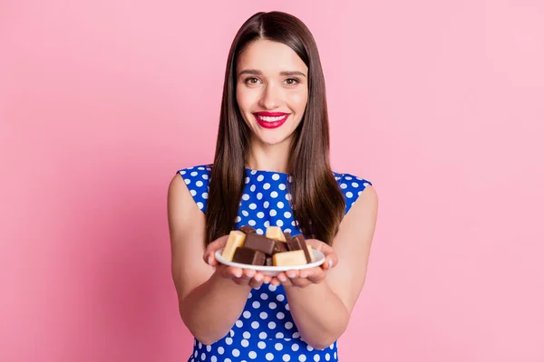 Porträtt av attraktiv glad flicka håller plattan med välsmakande färska godis ger dig isolerade över rosa pastell färg bakgrund — Stockfoto