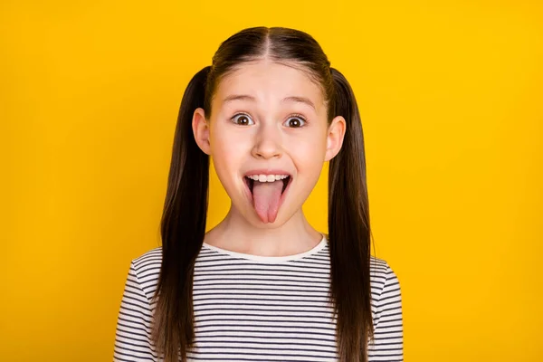 Foto de menina da escola feliz sorriso positivo grimace tongue-out isolado sobre fundo de cor amarela — Fotografia de Stock