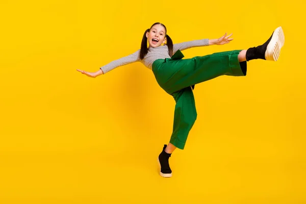 Low angle view full size profile side photo of young excited girl happy positive smile balance isolated over yellow color background — 图库照片