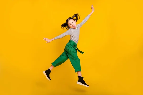 Full storlek profil sida foto av ung flicka glad positiv leende grimace tunga-out hoppa isolerad över gul färg bakgrund — Stockfoto