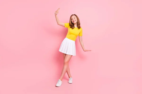 Foto de tamaño completo de lindo rubio niña danza desgaste amarillo camiseta falda zapatillas aisladas sobre fondo de color rosa —  Fotos de Stock