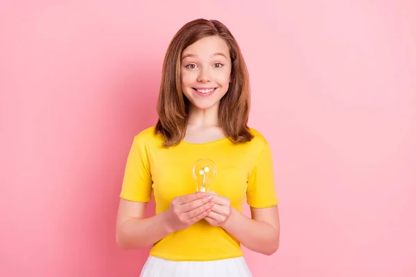 Фото красивой блондинки маленькая девочка держать свет носить желтую футболку изолированы на розовом фоне — стоковое фото