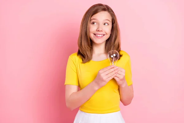 Foto van jong meisje blij positief glimlach houden lamp denken kijken leeg ruimte idee geïsoleerd over roze kleur achtergrond — Stockfoto