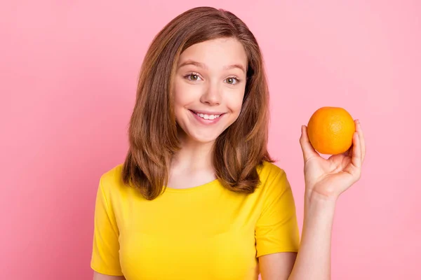 Foto de joven alegre chica feliz sonrisa positiva mantenga deliciosa fruta naranja fresca aislada sobre fondo de color rosa —  Fotos de Stock