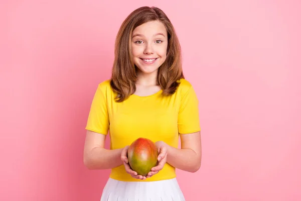 Foto de menina alegre feliz sorriso positivo segurar manga verão de frutas exóticas isolado sobre fundo cor-de-rosa — Fotografia de Stock