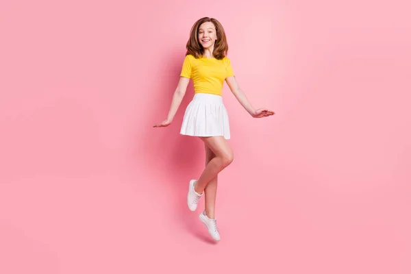 Volledige lengte foto van jonge school meisje gelukkig positieve glimlach veel plezier springen omhoog geïsoleerd over roze kleur achtergrond — Stockfoto