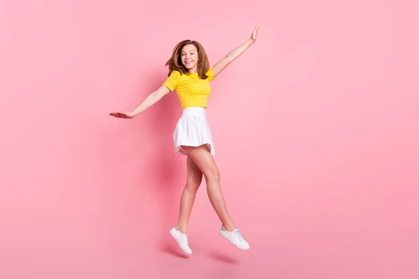Full Size Profil Seite Foto von jungen aufgeregten Mädchen glücklich positives Lächeln springen gehen Spaziergang isoliert über rosa Farbhintergrund — Stockfoto