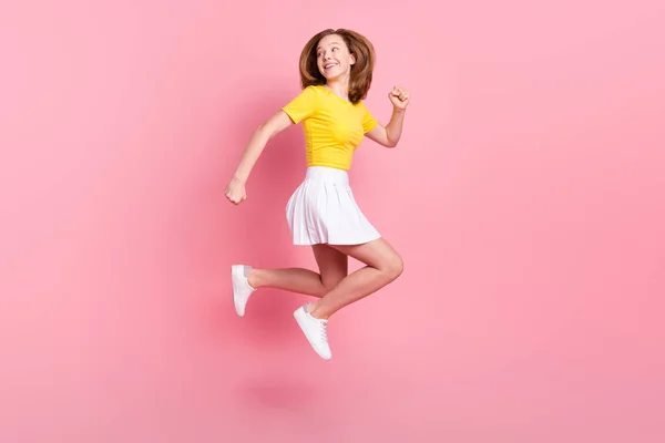 フルサイズプロフィール側の写真の若い女の子幸せな笑顔ジャンプアップ実行急いで見て空のスペース隔離されたピンク色の背景 — ストック写真