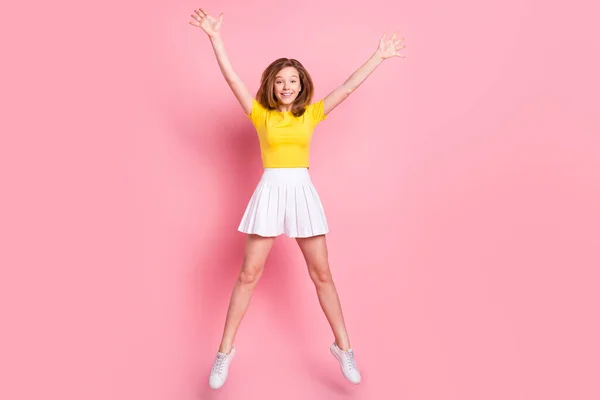 밝고 긍정적 인 미소를 짓는 소녀의 전신 사진 이 핑크 색 배경 위에 고립된 별 위로 점프하는 재미있는 경험을 한다 — 스톡 사진