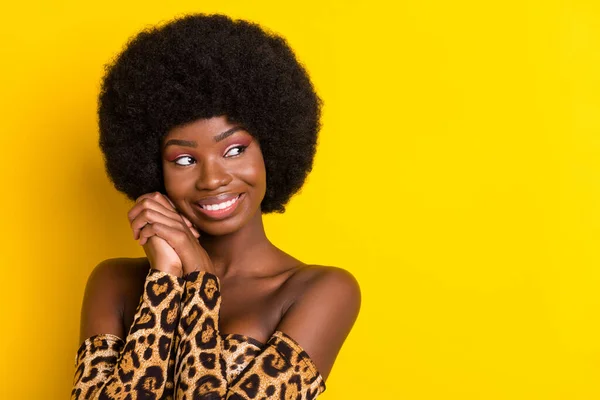 Foto de excitado sonhador pele escura mulher vestida roupa de leopardo sorrindo olhando espaço vazio isolado cor amarela fundo — Fotografia de Stock