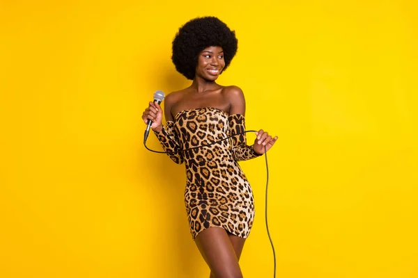 Photo portrait woman wearing leopard dress keeping microphone looking copyspace isolated vibrant yellow color background Stock Image