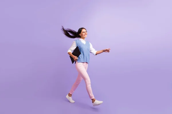 Tampilan ukuran tubuh penuh dari wanita ceria yang berjalan sambil membawa papan klip terisolasi di atas latar belakang warna ungu ungu — Stok Foto
