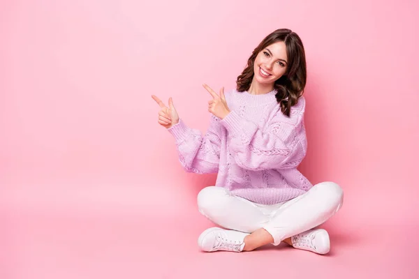 Retrato de la encantadora chica alegre sentada pose de loto demostrando solución de anuncio de espacio de copia aislado en el fondo de color pastel rosa —  Fotos de Stock