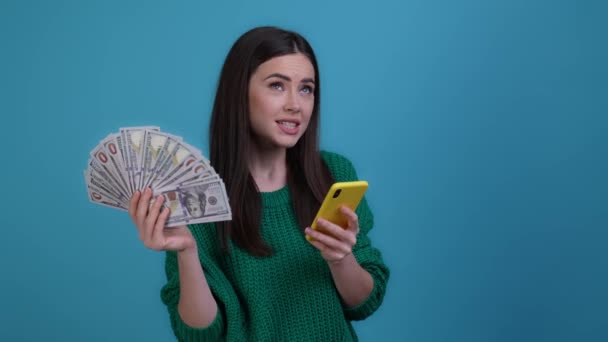 Trendy dame gebruiken apparaat te winnen gooien inkomen omhoog lucht geïsoleerde donkere kleur achtergrond — Stockvideo