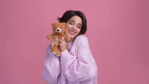 Positive lady cuddle teddy bear isolated pastel color background — Stock Video