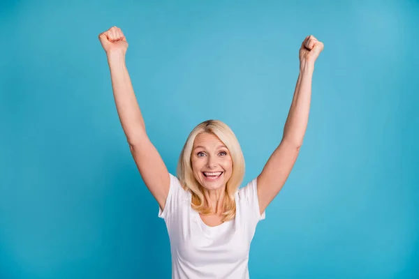 Photo of delighted old woman lucky win raise fists scream wear good look clothes isolated over blue color background — Stock Photo, Image