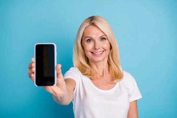 Mükemmel modern teknoloji aygıtı. Olumlu yaşlı kadın akıllı telefonu izole edilmiş mavi arka planda tut — Stok fotoğraf
