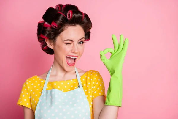 Portret van positief meisje knipoog toon oke teken dragen geel latex handschoenen geïsoleerd over pastel kleur achtergrond — Stockfoto