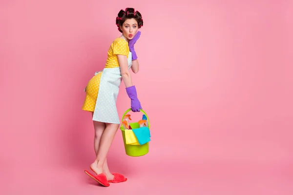 Corpo inteiro foto de mulher espantada toque luvas rosto segurar balde desgaste pontilhado vestido chinelos isolados no fundo cor pastel — Fotografia de Stock