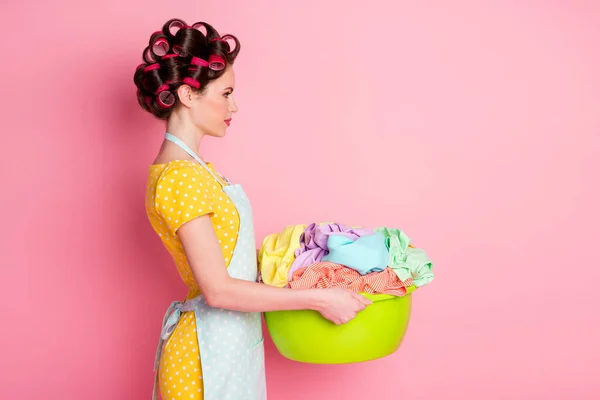 Profile side photo of serious maid girl hold basin dirty clothes look copyspace wear yellow skirt isolated pink color background — Stock Photo, Image