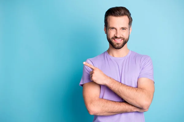 Foto di giovane uomo attraente felice sorriso punto dito spazio vuoto annuncio consiglia di scegliere isolato su sfondo di colore blu — Foto Stock