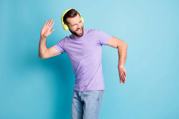 Photo portrait of bearded man enjoying music dancing wearing t-shirt jeans isolated on vivid blue color background — Fotografia de Stock