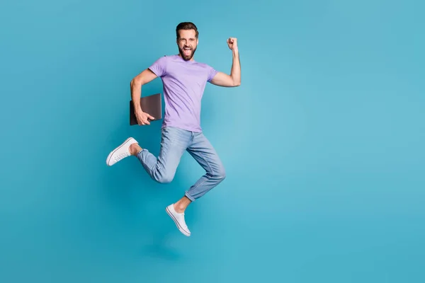 Full length body size photo of jumping high businessman with computer gesturing like winner smiling isolated on vivid blue color background — Zdjęcie stockowe