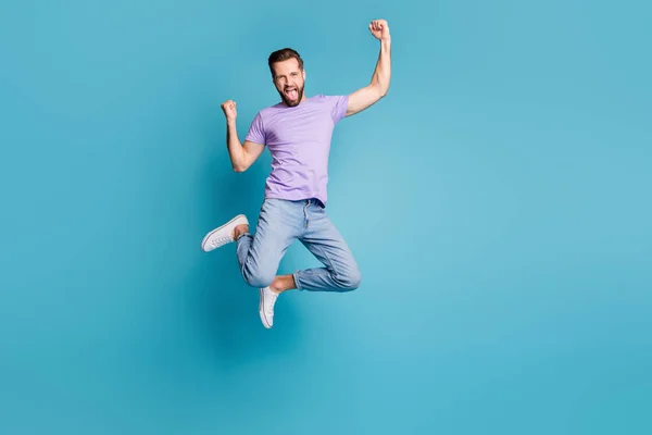 Полная длина тела фото прыгая вверх счастливый улыбающийся бородатый вентилятор кричать изолированы на ярком голубом фоне цвета — стоковое фото