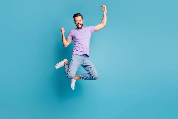 Ganzkörpergröße Foto von aufspringen glücklich lächelnd bärtigen Fan schreien isoliert auf lebendigen blauen Farbhintergrund — Stockfoto