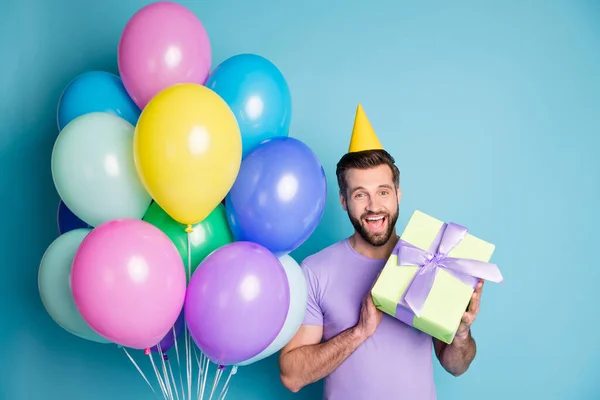 Foto-Porträt des lächelnden glücklichen Studenten halten verpacktes Geschenk feiert Geburtstagsparty lächelnd isoliert auf hellem Farbhintergrund — Stockfoto