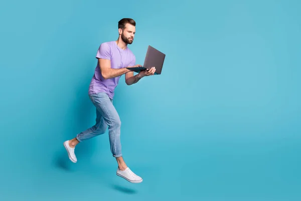 Pełna długość ciała rozmiar zdjęcie skupienia jumping man wpisując na laptopie odizolowane na jasnoniebieskim tle koloru — Zdjęcie stockowe