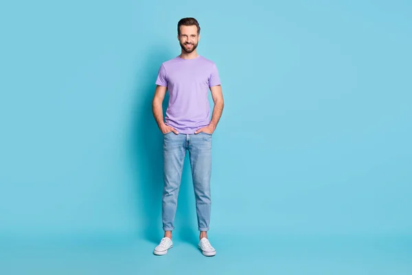 Foto em tamanho completo de jovem bonito sorriso feliz homem mãos no bolso isolado sobre fundo de cor azul — Fotografia de Stock