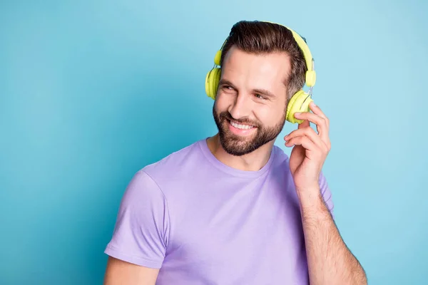 Fotoporträt von funky glücklich Student berühren grüne Kopfhörer genießen Musik lächelnd isoliert auf lebendigen blauen Hintergrund — Stockfoto