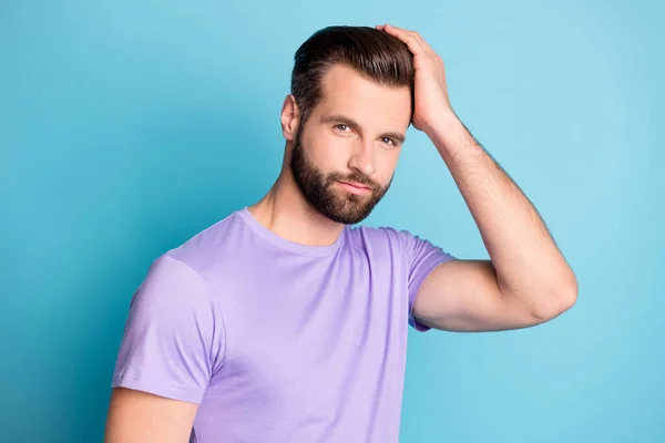 Kuva nuori komea mies onnellinen nauttia kädet kosketa hiukset uusi kampaus kulumista violetti t-paita eristetty sininen väri tausta — kuvapankkivalokuva