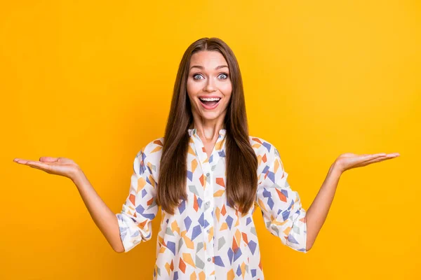 Kuva nuori innoissaan nainen onnellinen positiivinen hymy pitää kaksi kättä osoittaa tarjouksen promo eristetty keltainen väri tausta — kuvapankkivalokuva