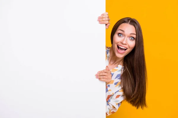 Photo portrait of crazy girl hiding behind white wall with blank space isolated on vivid yellow colored background — Stock Photo, Image