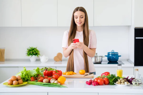 실내의 밝은 흰색 가정 부엌에서 기구를 사용하여 맛있고 맛있는 샐러드를 요리하는 유쾌 한 소녀의 모습 — 스톡 사진