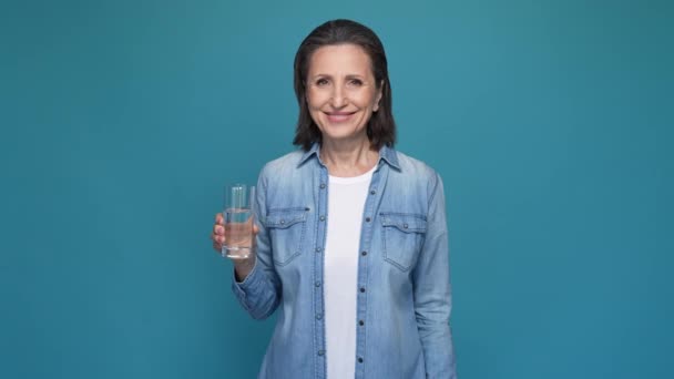Señora beber agua recomendar elección pulgar hacia arriba aislado color azul fondo — Vídeos de Stock