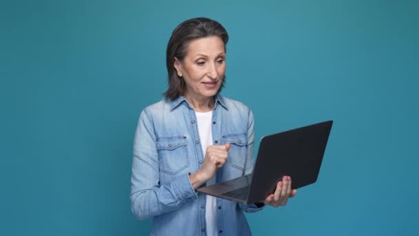 Senhora usar netbook procurando bate-papo isolado fundo cor azul — Vídeo de Stock