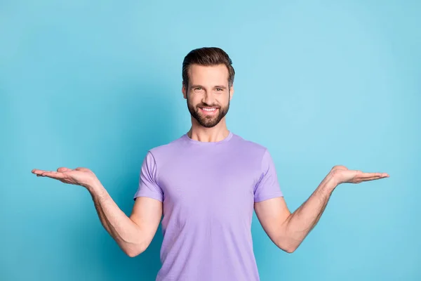 Foto do jovem homem feliz segurar as mãos palma demonstrar oferta produto anúncio promo isolado sobre fundo de cor azul — Fotografia de Stock